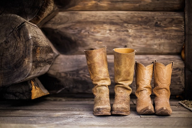 Braune Cowboystiefel in zwei unterschiedlichen Größen