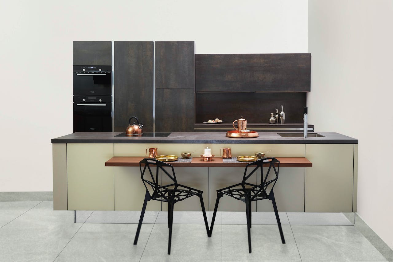 Küche mit Granit-Arbeitsplatte und Holztisch mit zwei schwarzen Metallstühlen